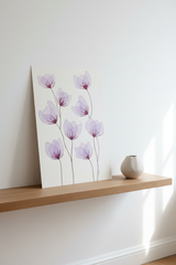 Original purple flower botanical artwork leaning on a light oak wood shelf