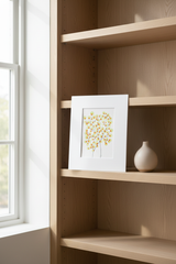 Green and orange tree botanical artwork on a light minimal shelf
