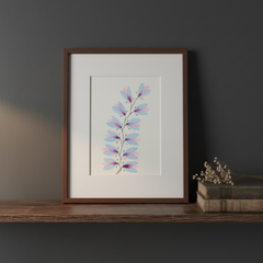 Blue and pink botanical ink painting framed on a dark moody wooden shelf