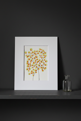 Green and orange tree botanical artwork on a dark moody shelf